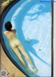 A naked woman laying in a swimming pool. 