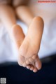 A close up of a person's bare feet on a bed.