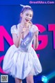 A woman in a white dress dancing on a stage.