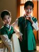 A couple of young girls dressed in traditional Korean clothing.