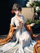 A woman in a kimono sitting on the ground next to a tree.