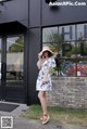 A woman wearing a white dress and a straw hat.