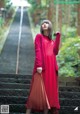 A woman in a red dress standing on some steps.