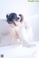 A woman in a white lingerie sitting on a bathtub.