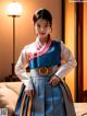 A woman in a blue and white hanbok standing on a bed.